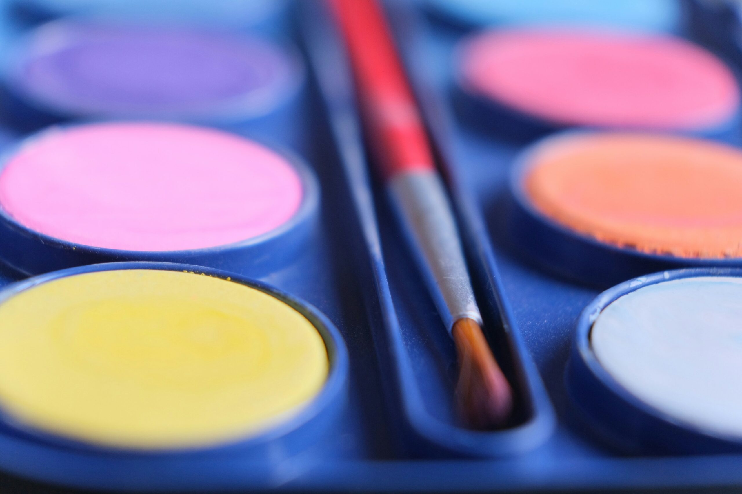 Close-up of hands applying makeup from a palette to create seamless layers