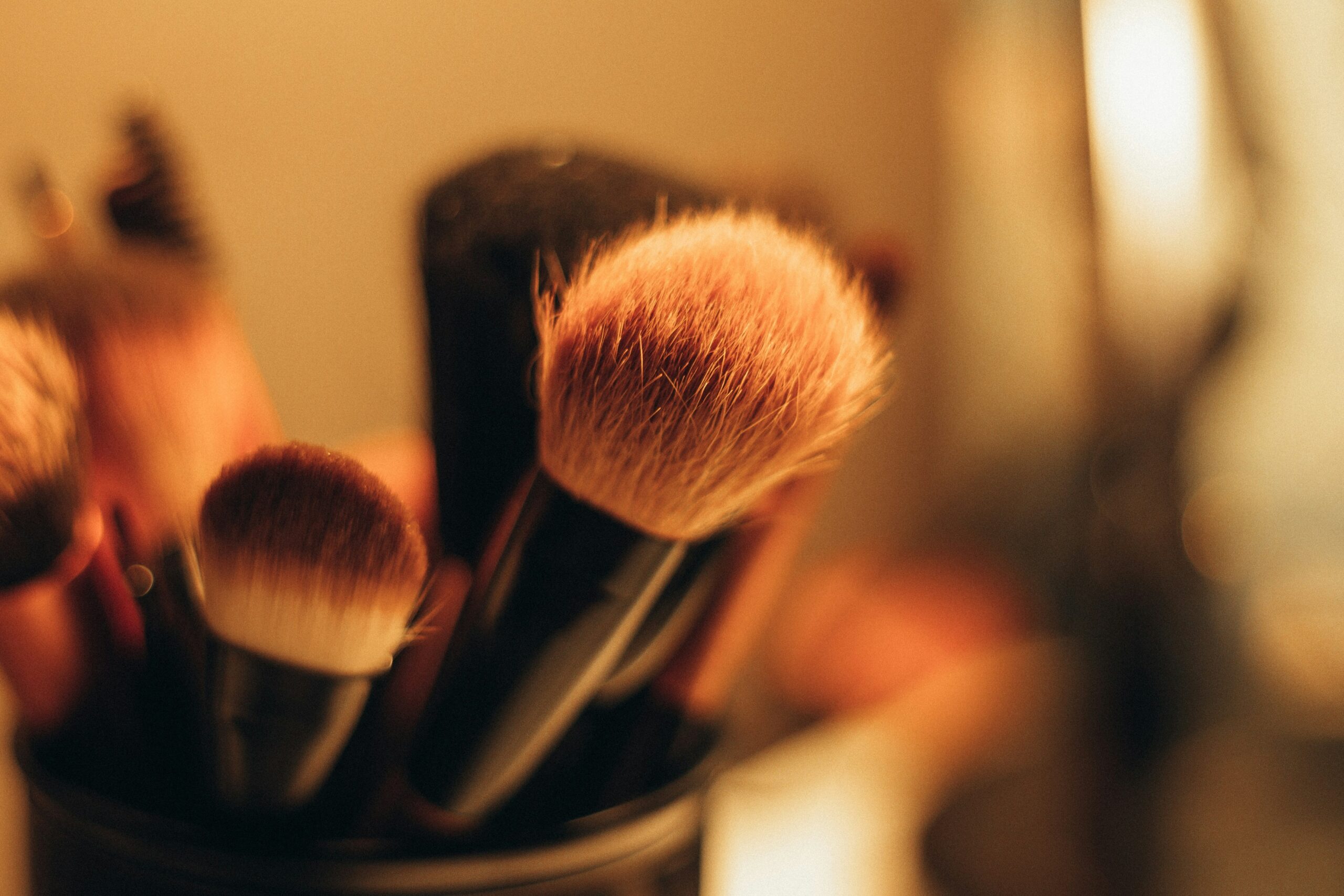 A minimalist compact eyeshadow palette lying next to a brush set.