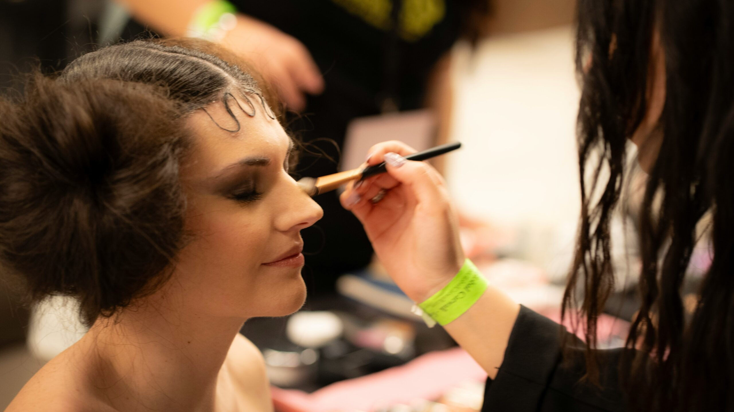 Makeup artist applying a dual functionality palette on a model backstage