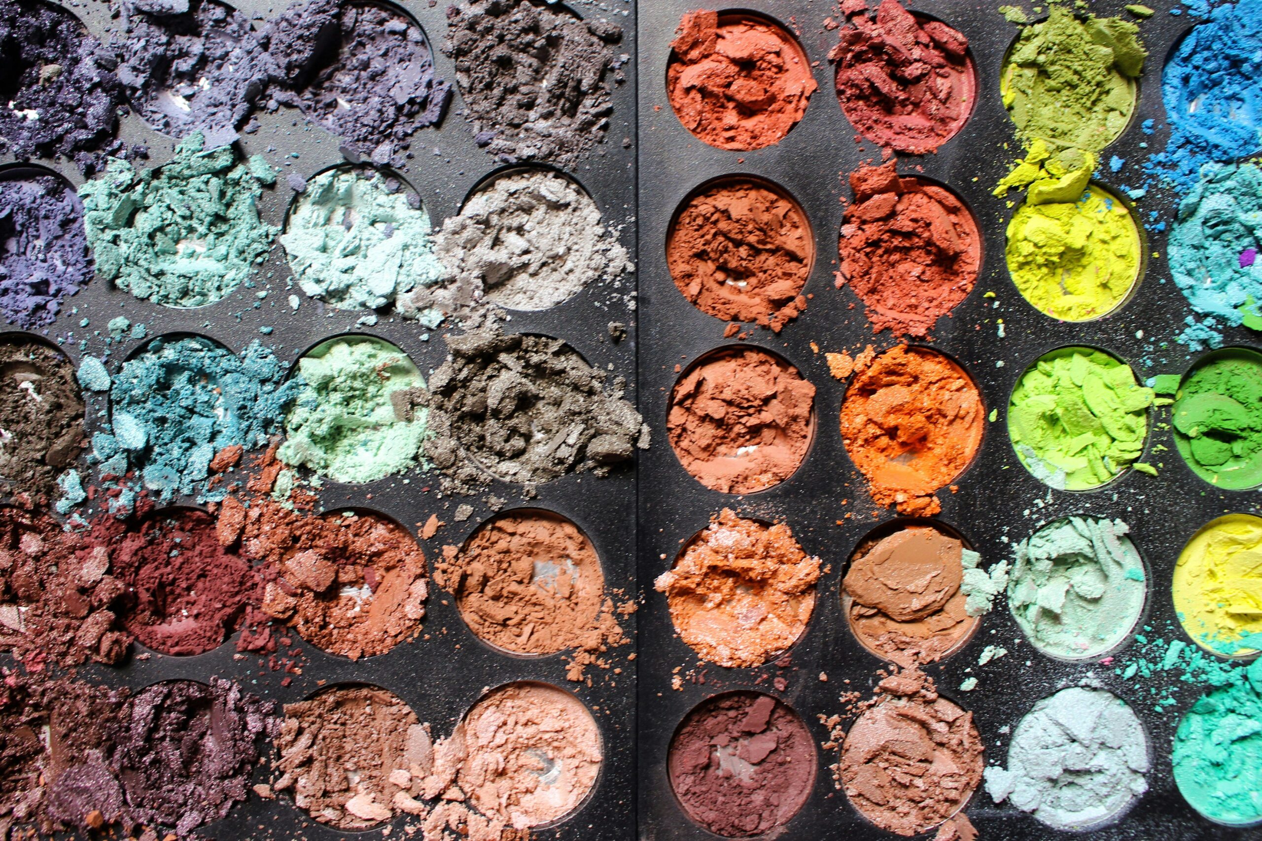 A vibrant eyeshadow palette featuring bold colors like electric blue, neon pink, and metallic gold.