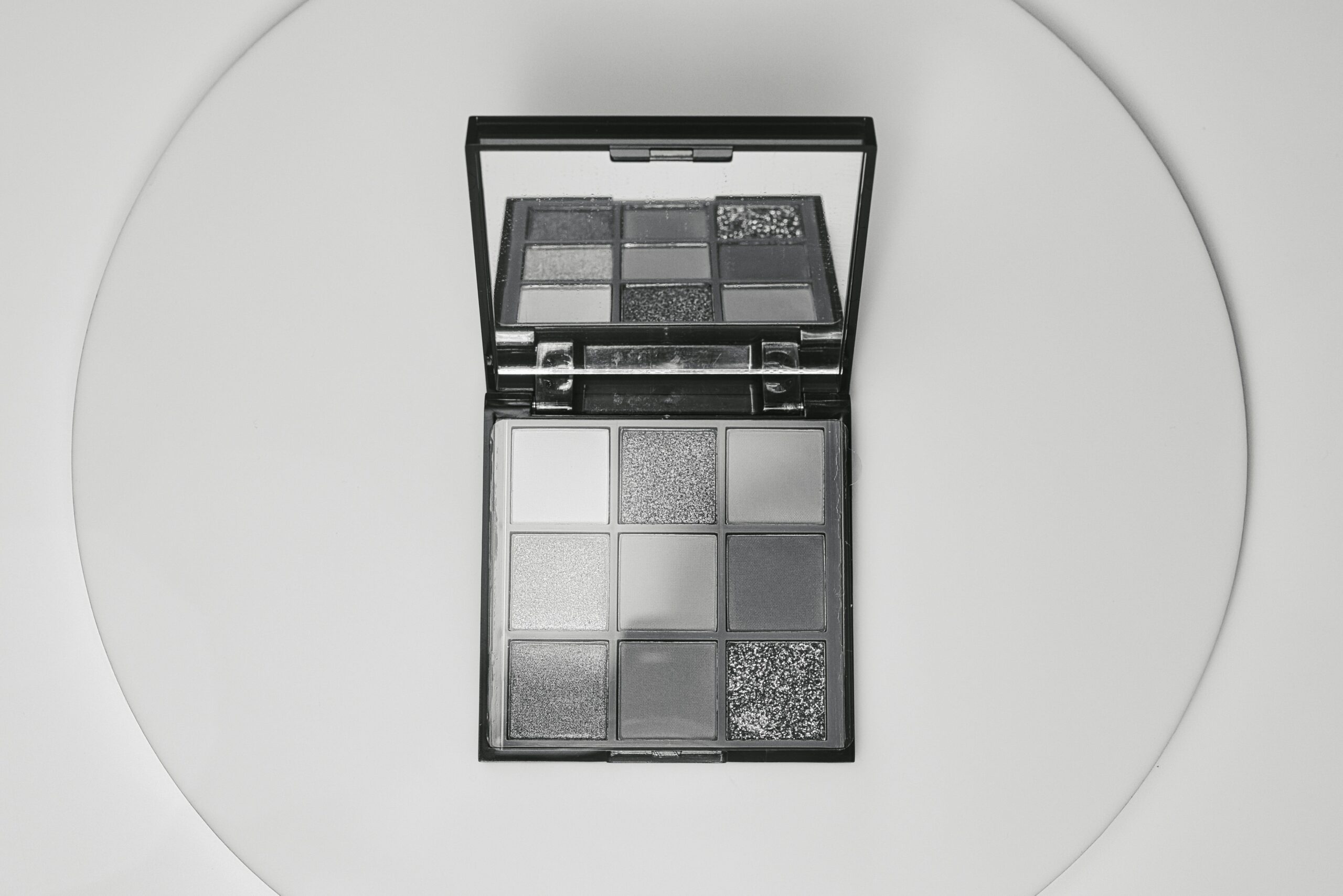 An open customizable makeup palette showing interchangeable color trays