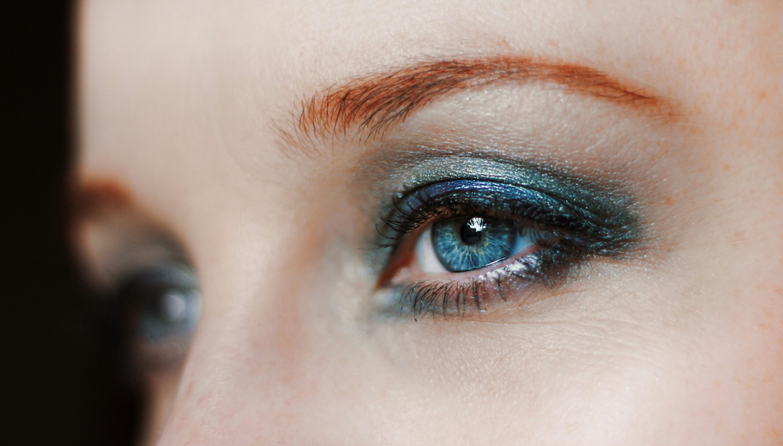 Close-up image of brushes applying eyeshadow on eyelid
