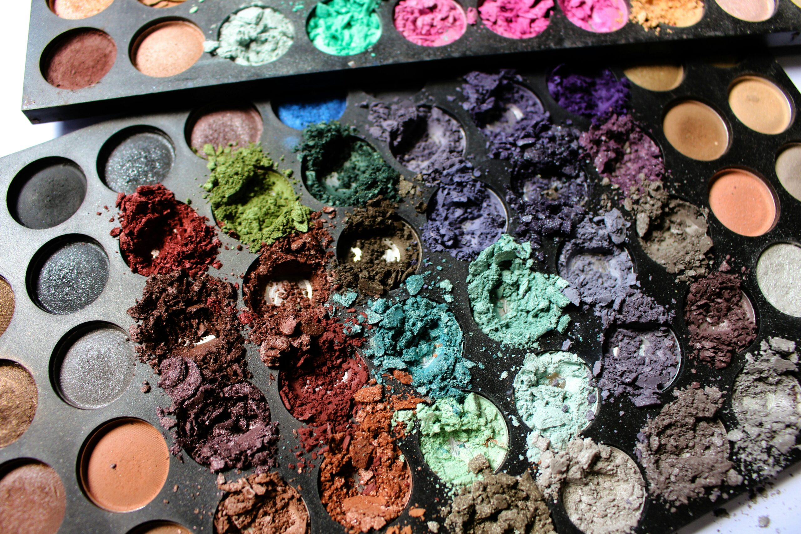 Smiling woman showcasing her compact all-in-one palette after applying makeup
