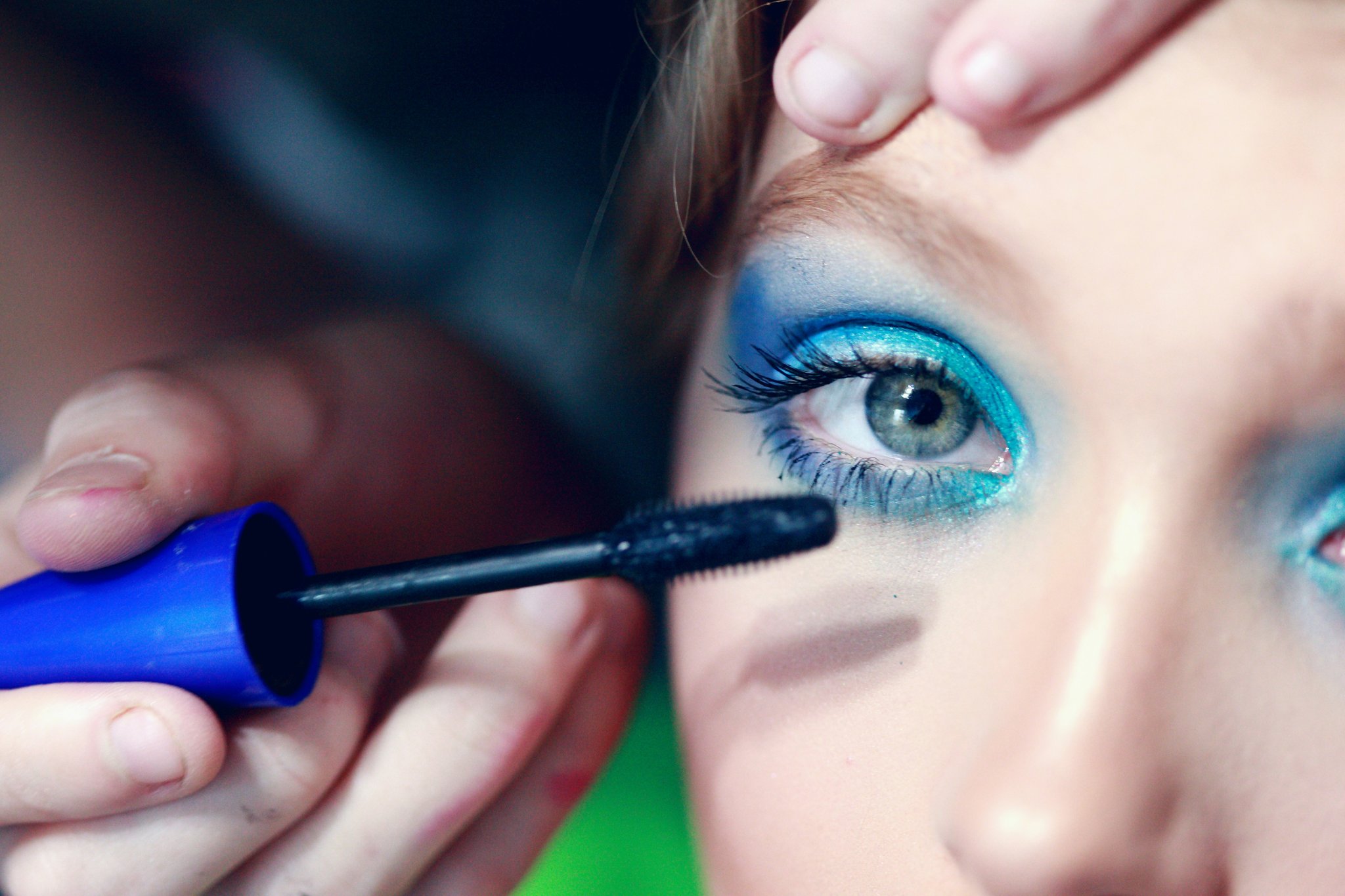 A model wearing bold green eyeshadow inspired by trending Euphoria styles.