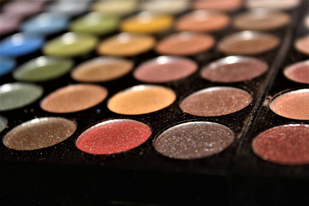 Close-up image of a professional makeup artist holding a cool tone eyeshadow palette.