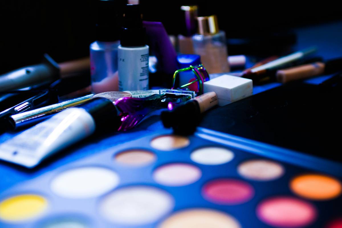 A close-up shot of a makeup artist applying eyeshadow using a multi-texture palette.
