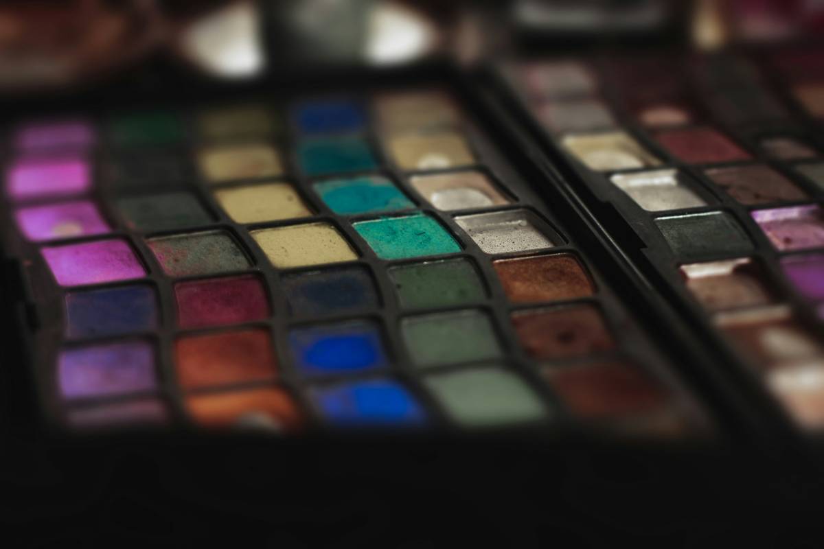 Model smiling confidently wearing natural-looking eyeshadow applied neatly using a small brush.