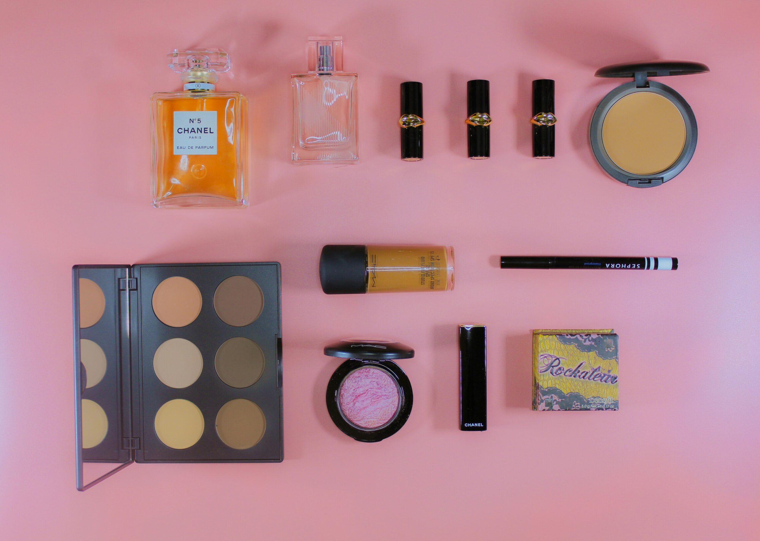 Flat lay featuring makeup and beauty items of a female traveler.