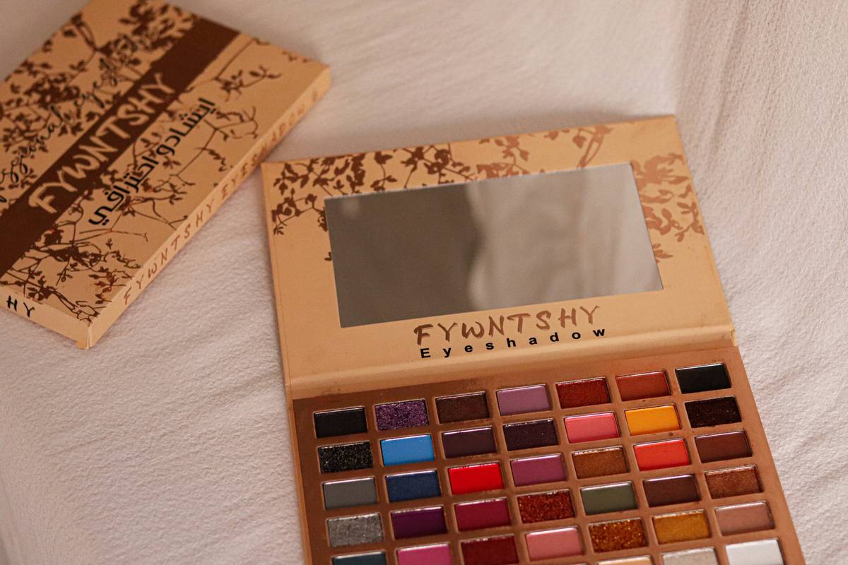 An organized makeup workspace featuring brushes, palettes, and other essentials laid out neatly.